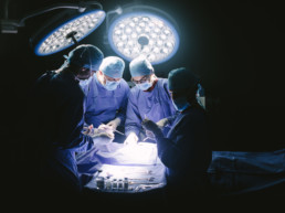 Team of professional surgeons performing surgery in operation room. Group of surgeon at work in operation theater.
